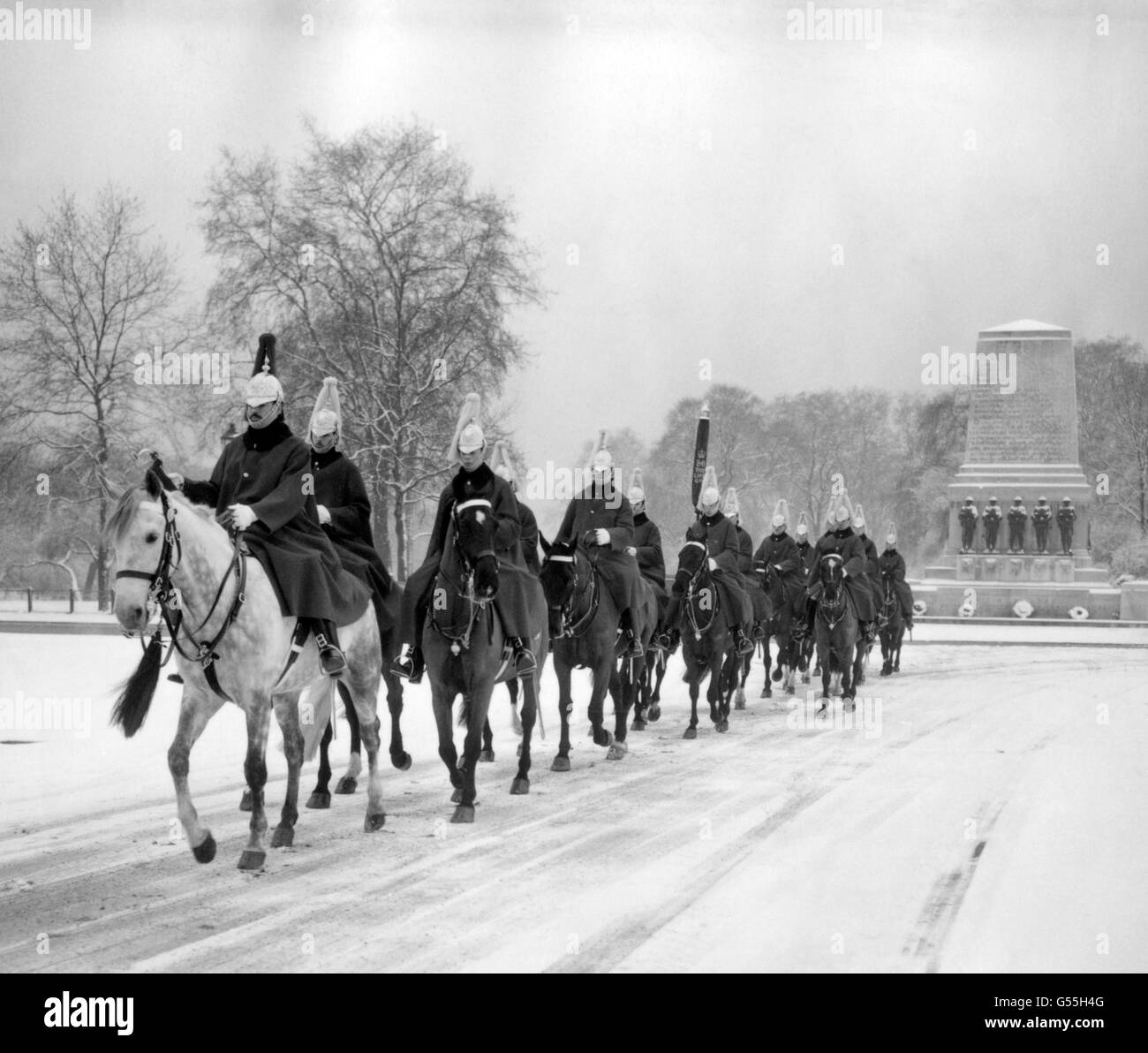 La cavalerie de la maison se met en route pour la cérémonie de relève de la garde à travers la neige sur la parade des gardes à cheval, Londres Banque D'Images