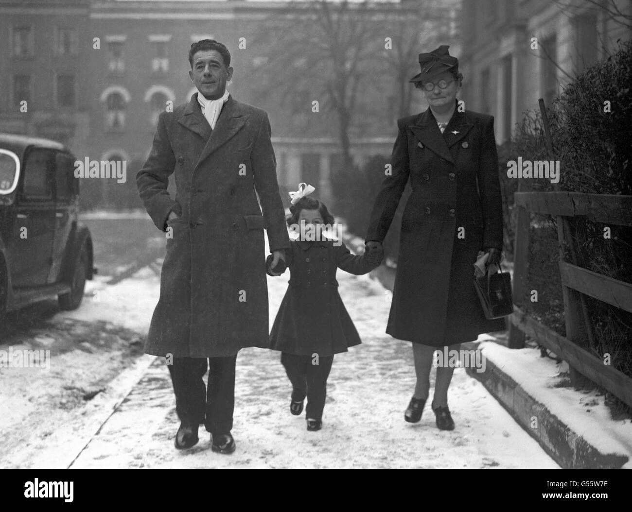 En marchant entre ses grands-parents, M. et Mme Charles Bushel, Tania Szabo se met en marche pour que le Palais de Buckingham reçoive la Croix de George qui a été décernée à titre posthume à sa mère, Violette Szabo, qui a été exécutée par les Allemands après avoir parachutée en France pour des missions d'espionnage. Banque D'Images