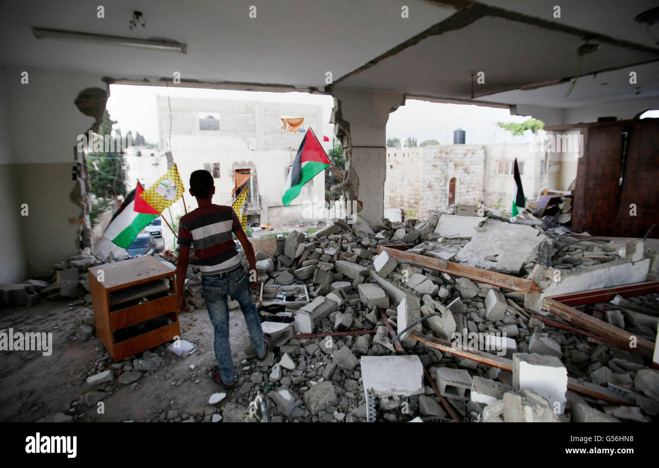 Qalqilya en Cisjordanie, territoire palestinien. 21 Juin, 2016. Un garçon palestinien inspecte l'accueil de l'Bashar Masalha qui a été démoli par l'armée israélienne dans la ville de Cisjordanie Kalkilya, le 21 juin 2016. Bashar Masalha a été tué dans la ville de Jaffa le 8 mars 2016, sous le prétexte de mener une attaque en coup de poignard. Son corps a été arrêté et remis à sa famille le 20 mars. Des sources locales ont dit que les soldats, accompagnés d'un bulldozer, ont fait irruption dans le village le mardi l'aube, entouré la maison familiale de Masalha, puis a pris ses résidents et verrouillé dans une pièce de leur voisin' Banque D'Images