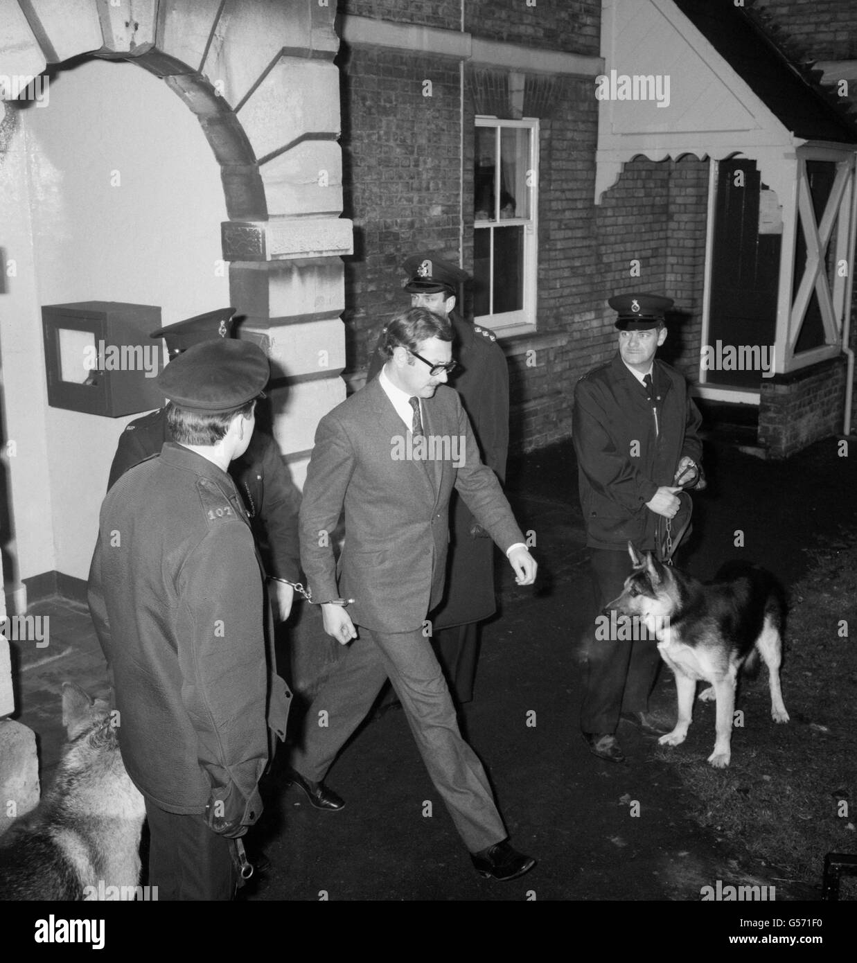 Le marchand d'antiquités Bruce Reynolds quitte Linslade, dans le Bedfordshire, menotté à un garde après avoir été remis en garde à vue, accusé d'être préoccupé par le grand vol de train en 1963. Banque D'Images