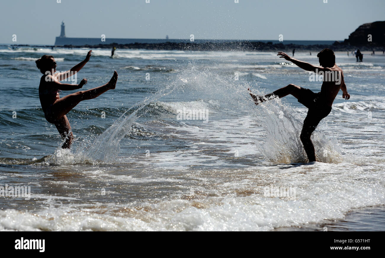 Matty Glover 18 et Charlotte Brett 19 se refroidissent dans la mer du Nord pendant la vague de chaleur printanière à la plage de Tynemouth, Tyne et Wear, North Tyneside. Banque D'Images