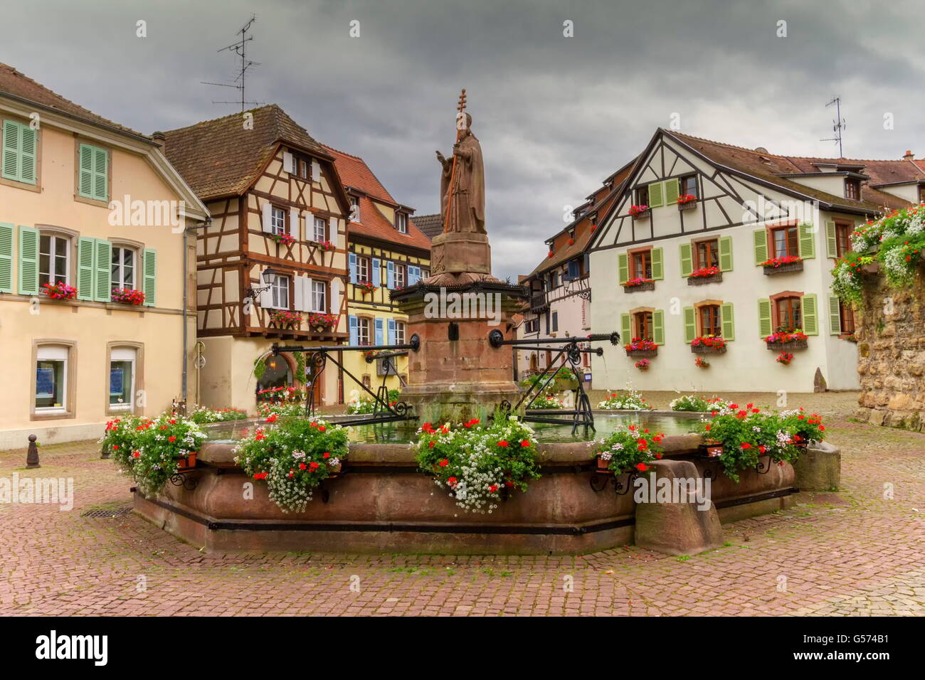 Saint-léon fontaine et maisons à colombages traditionnelles à Eguisheim, Alsace, France Banque D'Images