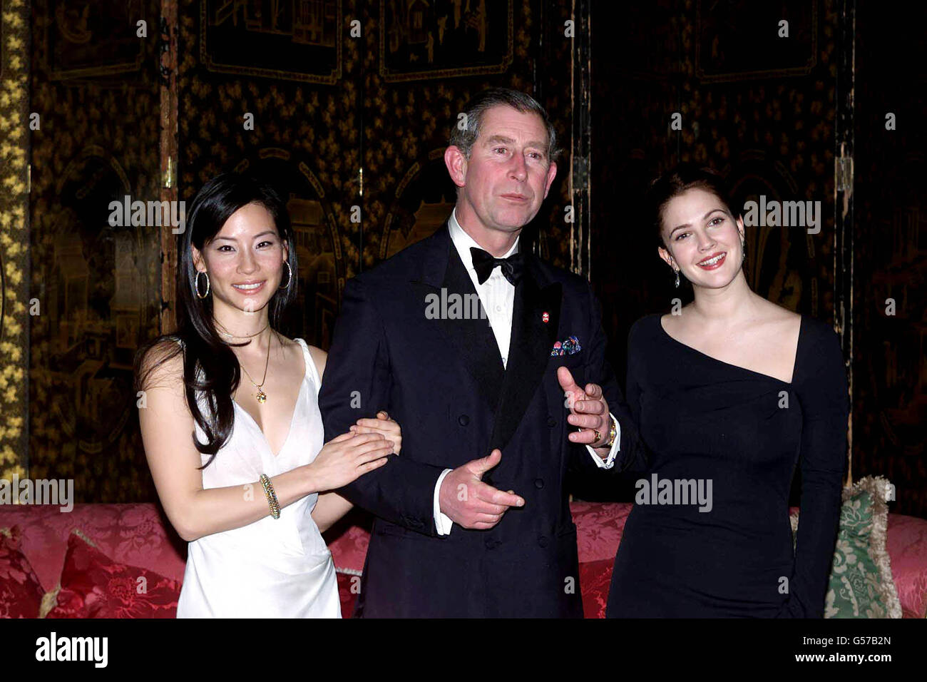 Le prince de Galles, flanqué de deux anges de Charlie, a accueilli un dîner pour les actrices Lucy Liu (à gauche) et Drew Barrymore au Palais St James en aide à la Fiducie du prince. Banque D'Images