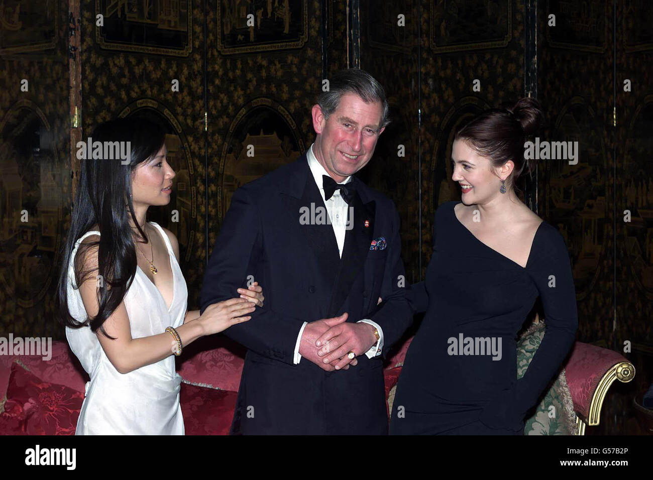 Le prince de Galles, flanqué de deux anges de Charlie, a accueilli un dîner pour les actrices Lucy Liu (à gauche) et Drew Barrymore au Palais St James en aide à la Fiducie du prince. Banque D'Images