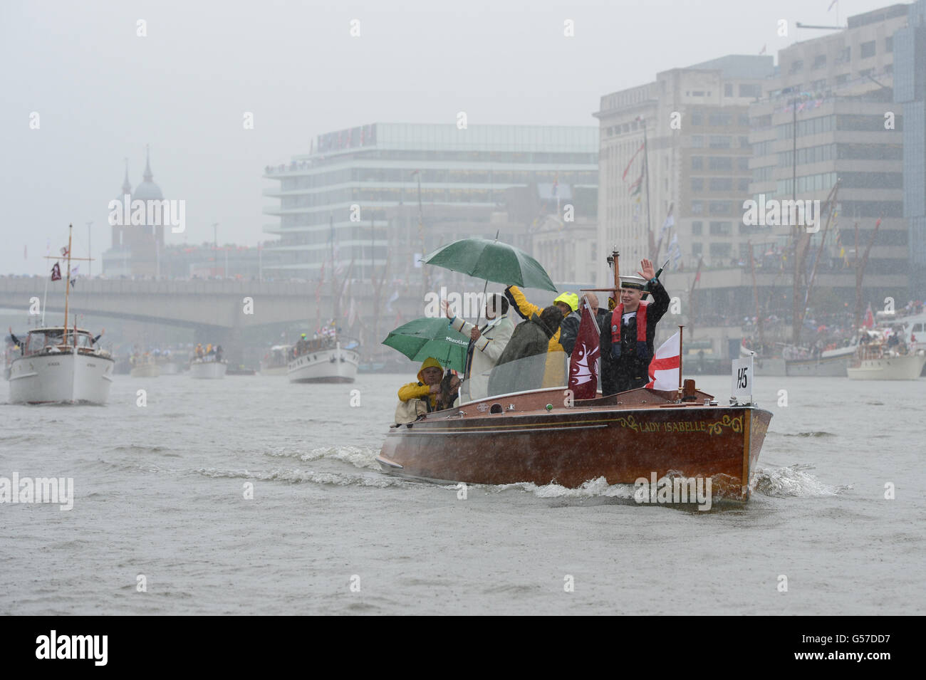 Les gens naviguent sous la pluie lors du Thames Diamond Jubilee Pageant sur la Tamise à Londres. Banque D'Images
