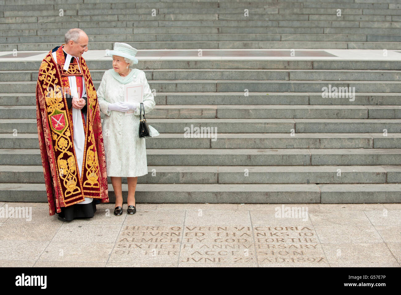 La reine Elizabeth II voit une inscription au pied des marches de la cathédrale Saint-Paul, dans le centre de Londres, à côté du doyen de St-Paul, le Dr David Ison, à la suite d'un service d'action de grâce. Banque D'Images
