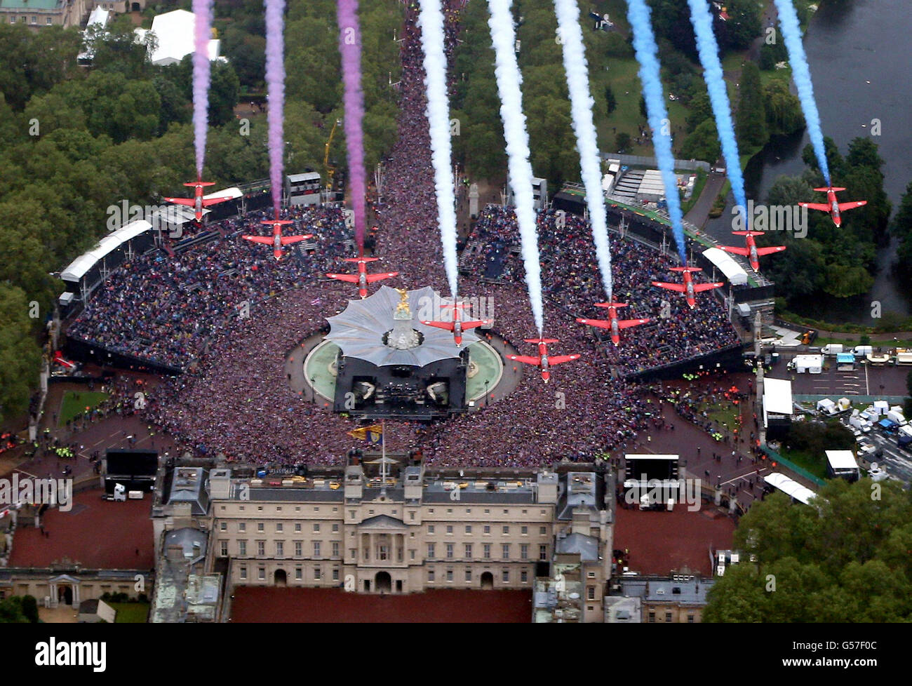 Les flèches rouges survolent en formation le palais de Buckingham à Londres tandis que la famille royale se trouve sur le balcon. Banque D'Images