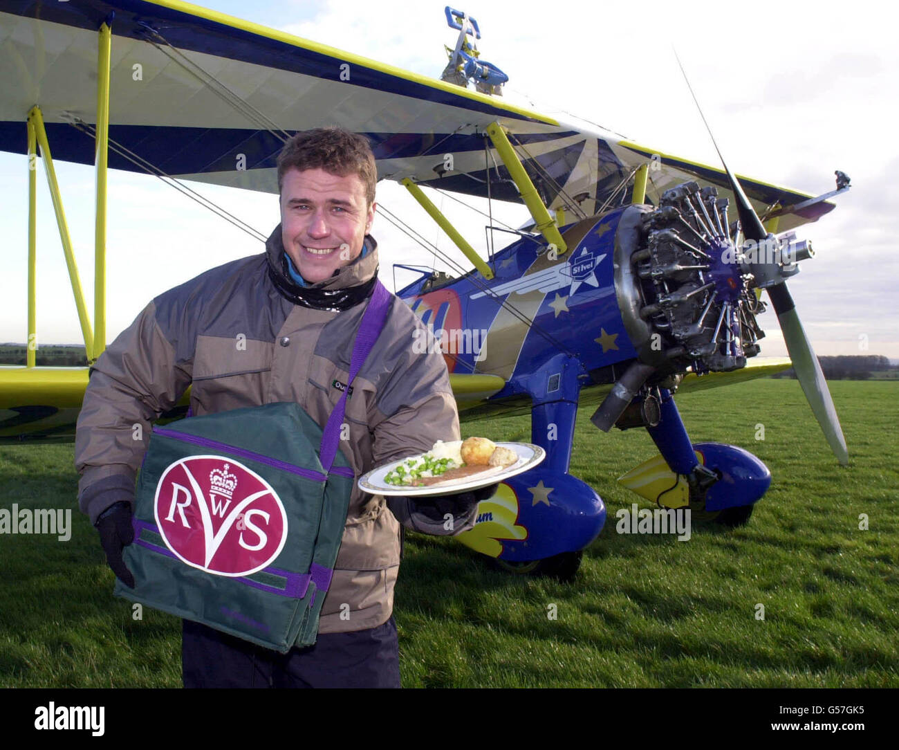 Craig Phillips, gagnant de Big Brother, se promenant dans un Boeing 1940 à bord d'un bi-avion Staarman avant de livrer un repas féminin de service volontaire royal à l'aérodrome de Rendcomb à Gloucestershire. L'exploit de rappeler aux personnes WRVS de livrer des repas sur roues. Banque D'Images