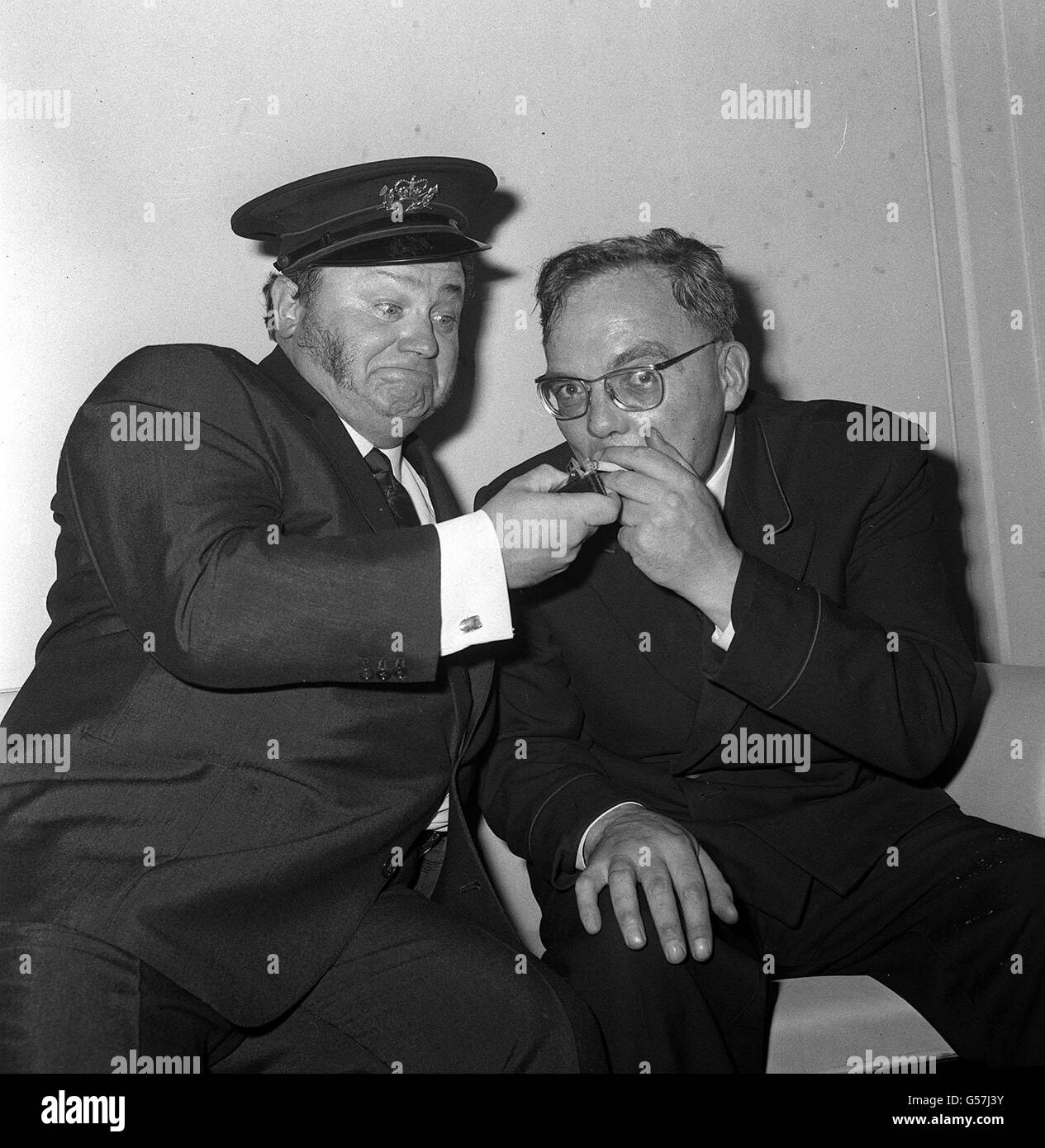 Allan Smethurst (à droite), le chanteur Postman, demande, et Harry Secombe oblige en fournissant une lumière comme les deux comédiens chanteurs se sont réunis au Variety Club. * 23/12/2000: Allan Smethurst, le chanteur Postman, décédé à l'âge de 73 ans. Il a eu un certain nombre de hits dans les années 60, y compris I Miss My Miss de DISS, mais son plus grand succès a été HEV Yew Gotta Loight Boy qui lui a gagné et Ivor Novellow Award en 1966. M. Smethurst s'est cassé la hanche en automne il y a trois mois et sa santé s'est détériorée. Banque D'Images