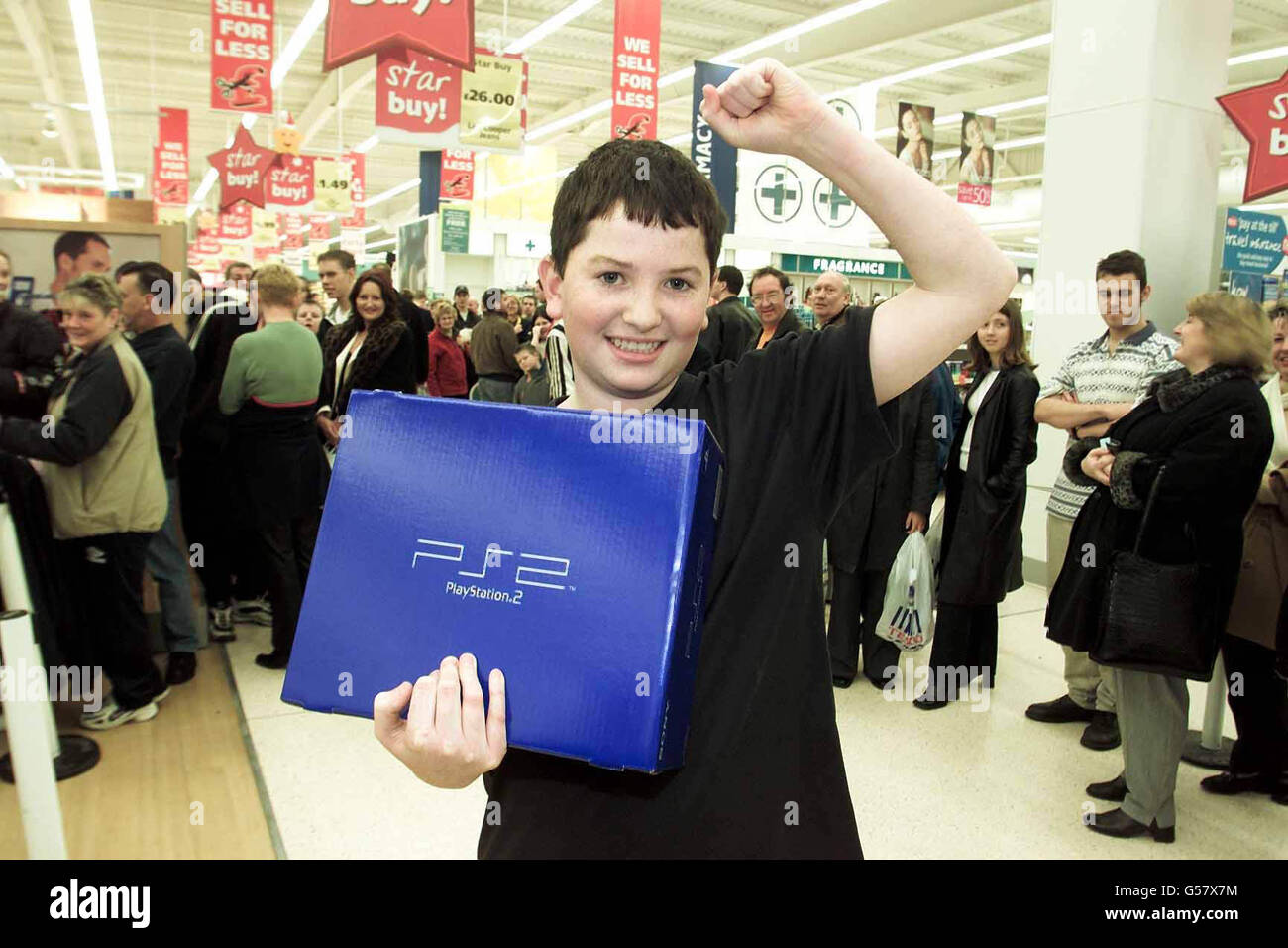 Joe Jones, âgé de 14 ans, présente sa nouvelle PlayStation 2 au magasin Kingston Park Tesco de Newcastle. Joe a mis la file d'attente pendant six heures et a été la première personne à obtenir l'une des nouvelles consoles de jeux au magasin. Banque D'Images