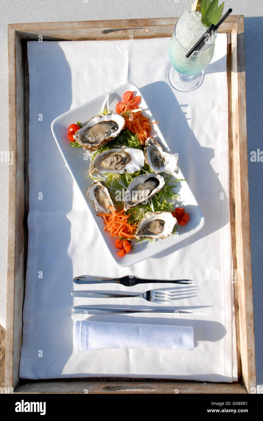 Plateau avec les huîtres et un jus de fruit sur un lit dans la Blue Marlin beach restaurant, Ibiza, Espagne Banque D'Images
