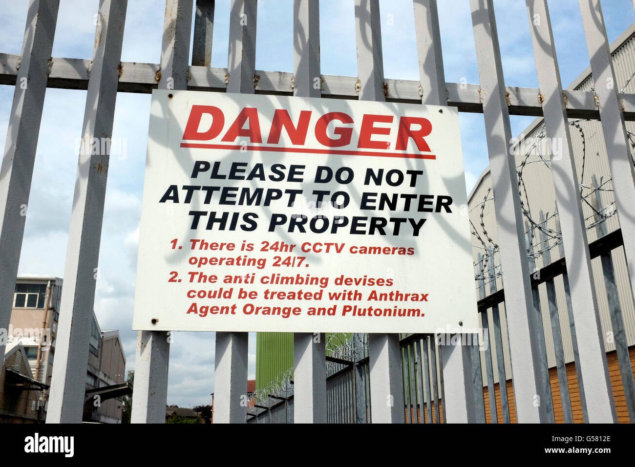 Panneau d'avertissement à l'extérieur d'une zone industrielle à Perivale Londres indiquant qu'il ne pouvait qu'être protégés par l'anthrax, et l'agent orange. Banque D'Images