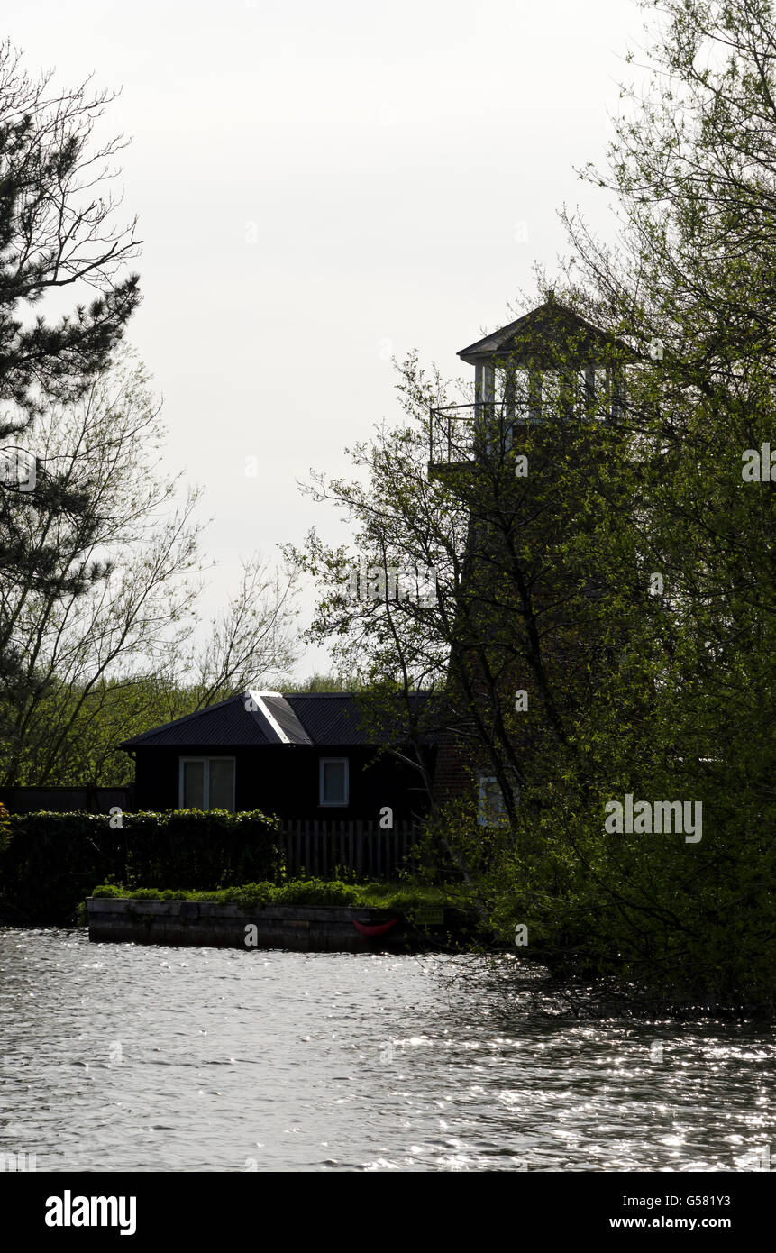 Maison au bord de l'eau avec un moulin à vent près de la tour de guet Horning sur la rivière Bure dans les Norfolk Broads, Angleterre. Banque D'Images