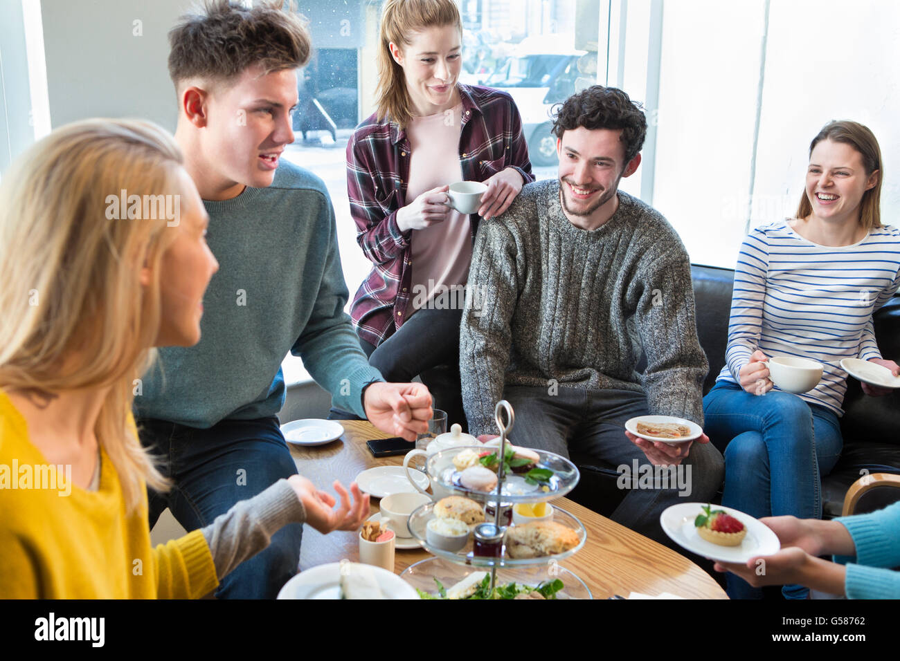 Groupe d'amis ayant le thé l'après-midi ensemble dans un café. Banque D'Images