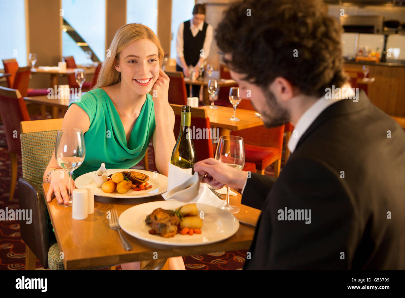 Jeune couple de conversations au un repas au restaurant. Banque D'Images