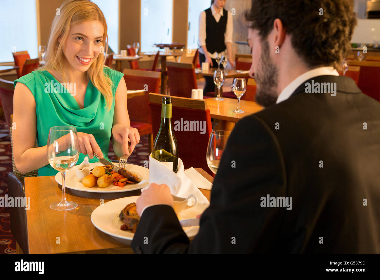 Jeune couple de conversations au un repas au restaurant. Banque D'Images