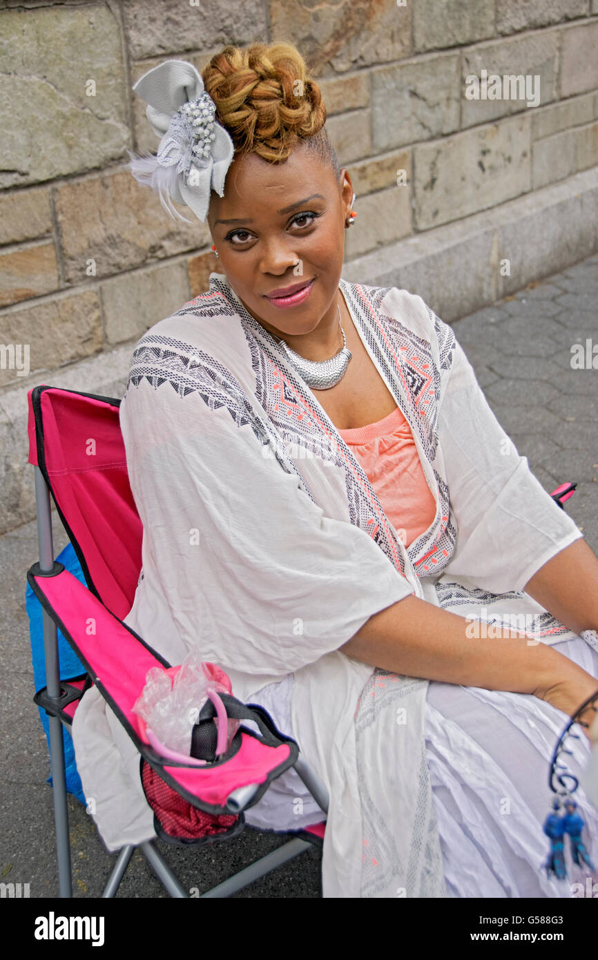 Portrait d'une belle femme assise créateur de bijoux portant une fleur dans ses cheveux à Union Square Park à New York City Banque D'Images