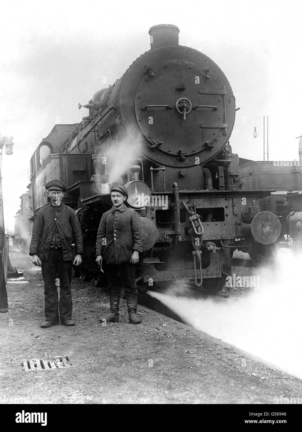 1919: Les cheminots allemands se tenant à côté d'un des moteurs à vapeur se sont rendus par les Allemands aux alliés conformément aux termes de l'Armistice de novembre 1918 qui a mis fin à la première Guerre mondiale. Banque D'Images
