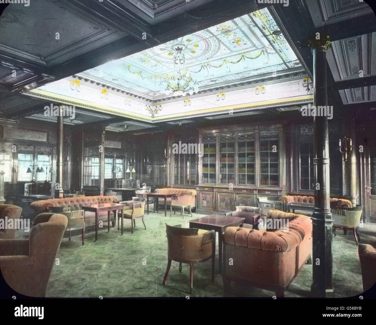 Purer Luxus erwartet die Passagiere der RMS Titanic in einem der vielen Aufenthaltsräume, die sogar mit einer Bibliothek ausgestattet sind. Le premier voyage du Titanic 1912 - salon de luxe à bord du Titanic - Carl Simon, toboggan en verre de couleur main - histoire, historique Banque D'Images