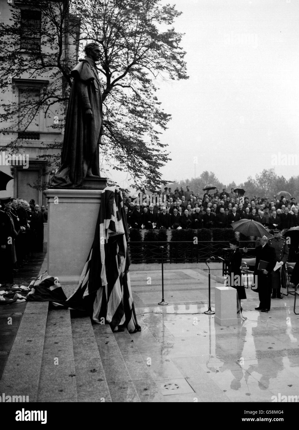 Par temps humide, la Reine dévoile le monument commémoratif national de son père, feu le roi George VI, à Carlton Gardens, Londres. La statue montre le roi en uniforme naval. C'est l'oeuvre du sculpteur William McMillan. Banque D'Images