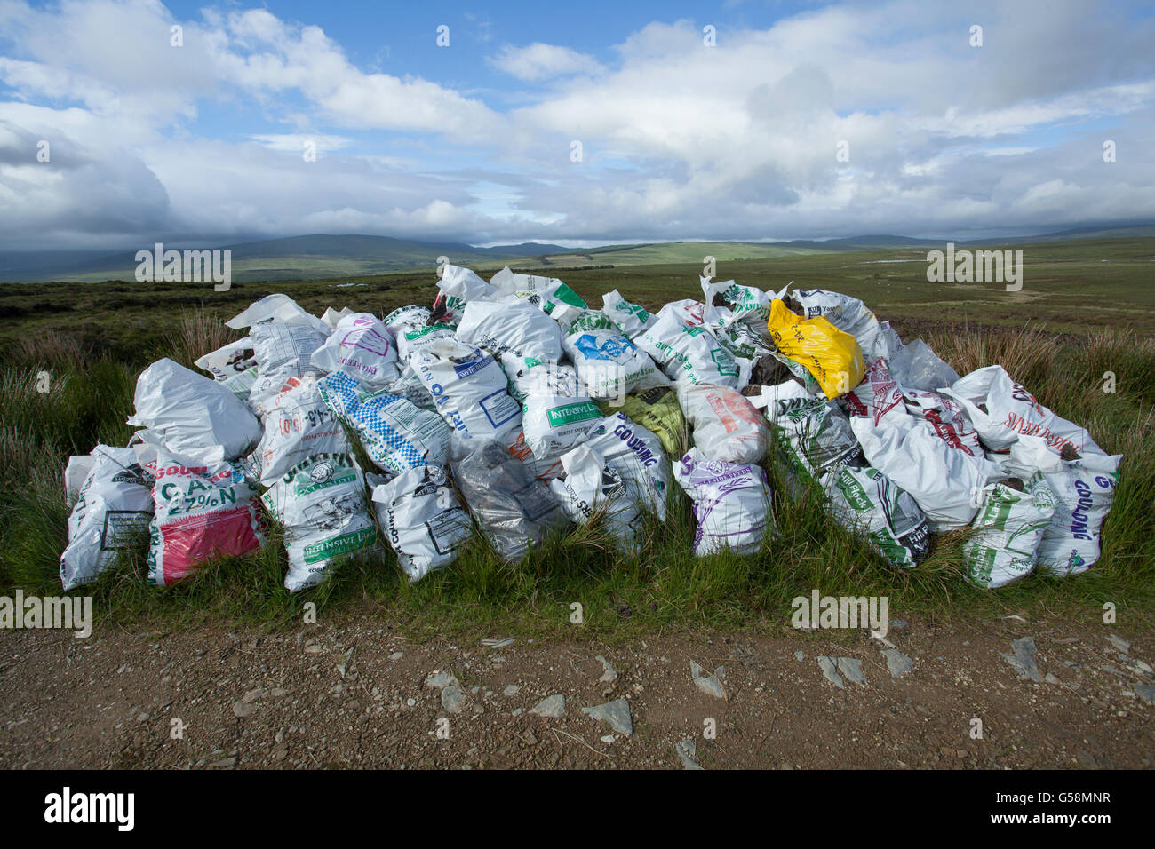 Sacs de tourbe tourbe empilés sur le côté de la route en Irlande Banque D'Images