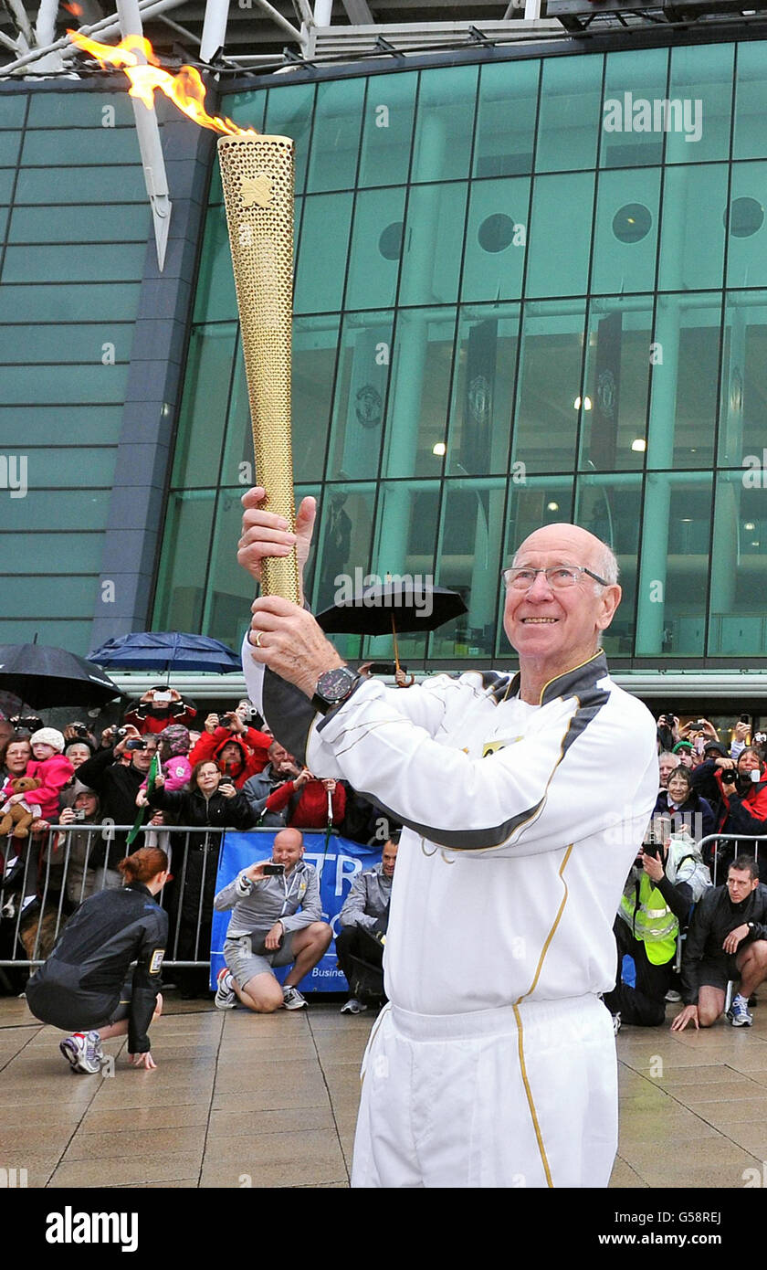 Torchelor 005 Sir Bobby Charlton tient la flamme olympique à l'extérieur du stade de football d'Old Trafford sur la jambe du relais de la flamme entre Salford et Moss Side. Banque D'Images