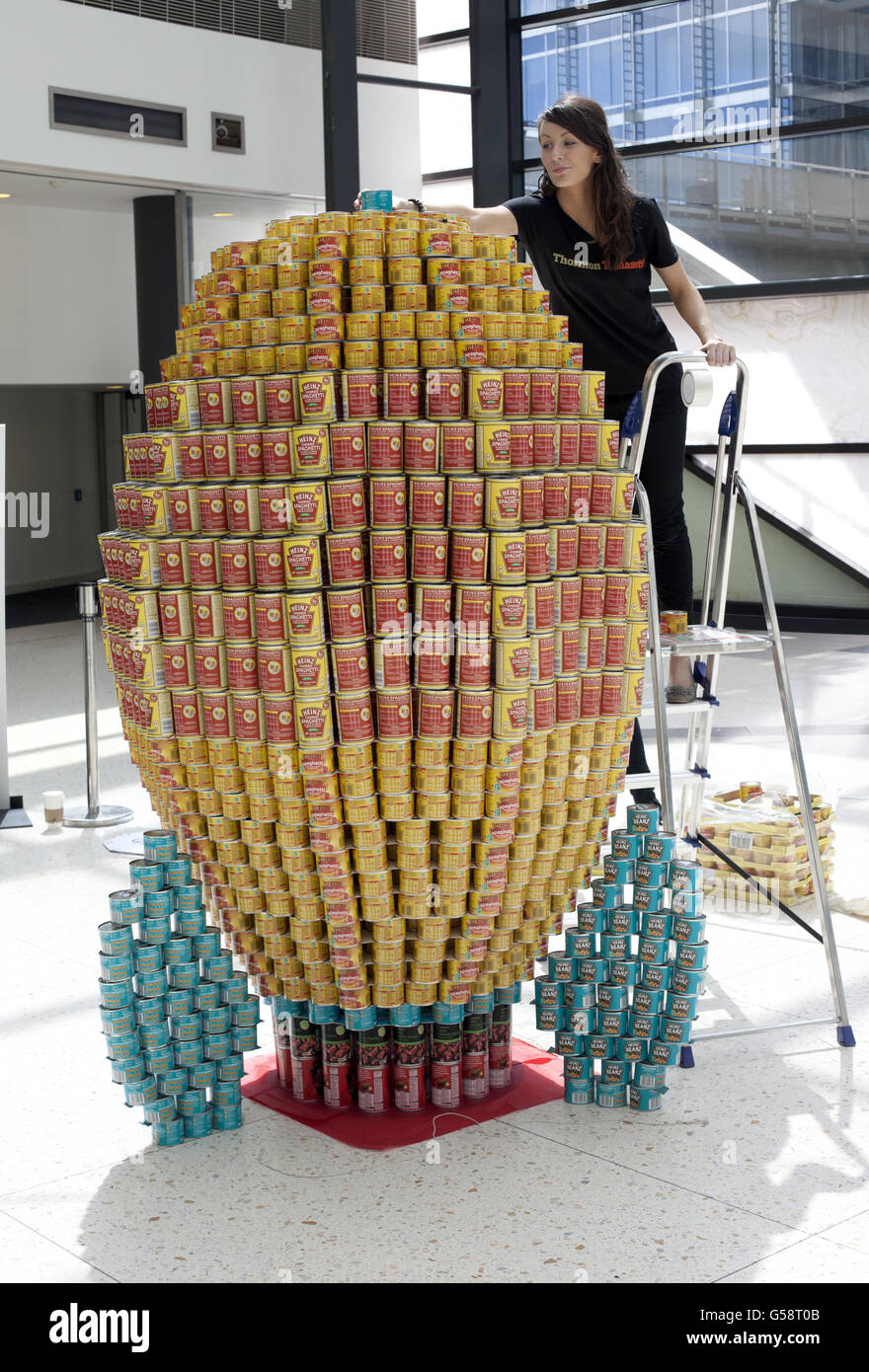 Laura Hannigan, de Thornton Tomasetti LTD, met la touche finale à un petit pas pour CAN, un pas géant pour Cankind, une sculpture d'une fusée dans le cadre du concours Canfortion à Canary Wharf à Londres. Banque D'Images