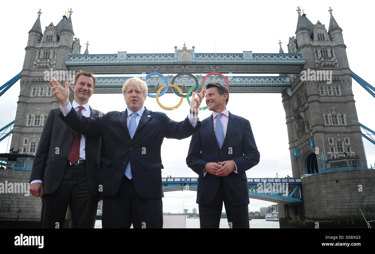 (De gauche à droite) Culture Secrétaire aux médias et aux sports Jeremy Hunt, Maire de Londres Boris Johnson et Président du Comité d'organisation des Jeux Olympiques et Paralympiques de Londres, Lord Sebastian COE en face du Tower Bridge à Londres où les anneaux olympiques ont été accrochés ce matin pour préparer le début des Jeux olympiques de Lodnon en 2012. Banque D'Images