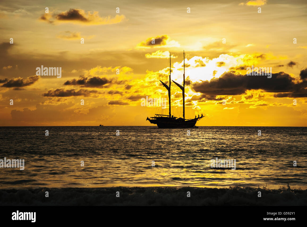 La mer spectaculaire et transports bateau en couleur de coucher de soleil avec plus de tons sombres Banque D'Images