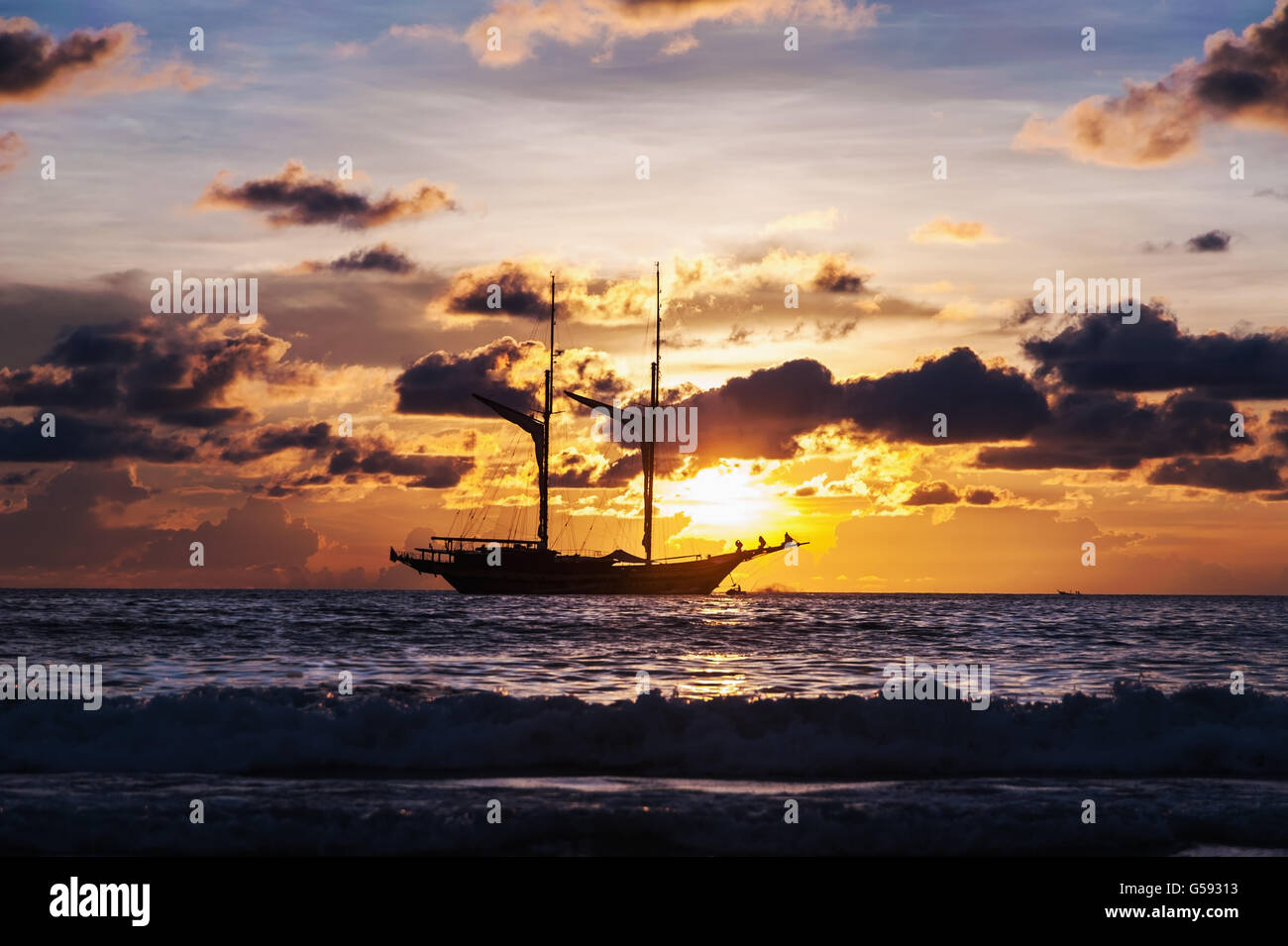 La mer spectaculaire et transports bateau en couleur de coucher de soleil avec plus de tons sombres Banque D'Images