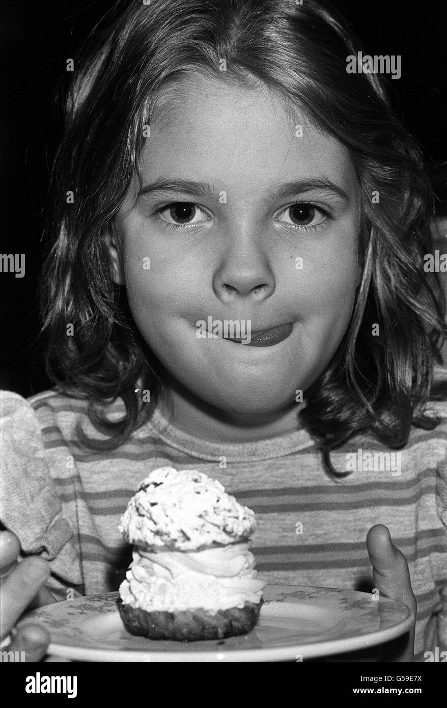 L'actrice américaine de sept ans Drew Barrymore, star du film et, sur le point de manger un thé anglais à l'Inn on the Park, à Londres.Drew est la petite-fille de la star de cinéma silencieuse John Barrymore. Banque D'Images