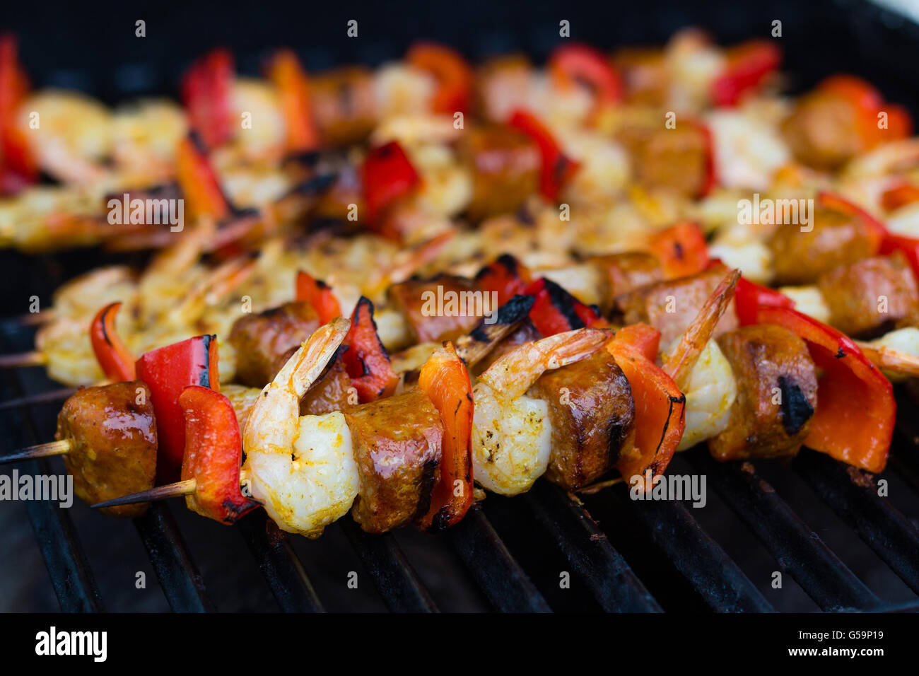 Crevettes cajun épicé brochettes et saucisses sur le barbecue Banque D'Images