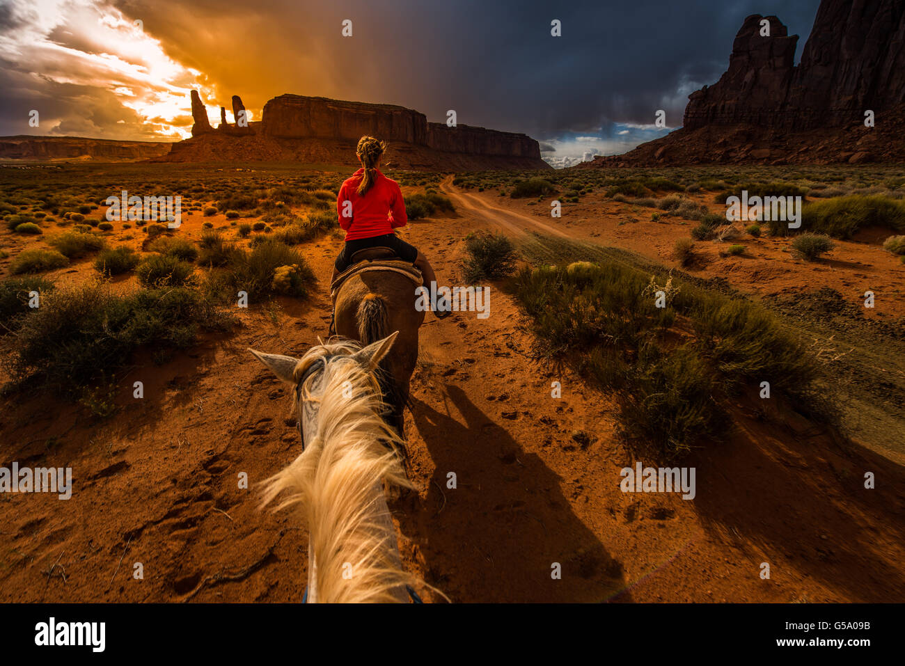 Monument Valley l'équitation première personne vue depuis le cheval avec Ciel de coucher du soleil sur les trois soeurs Banque D'Images