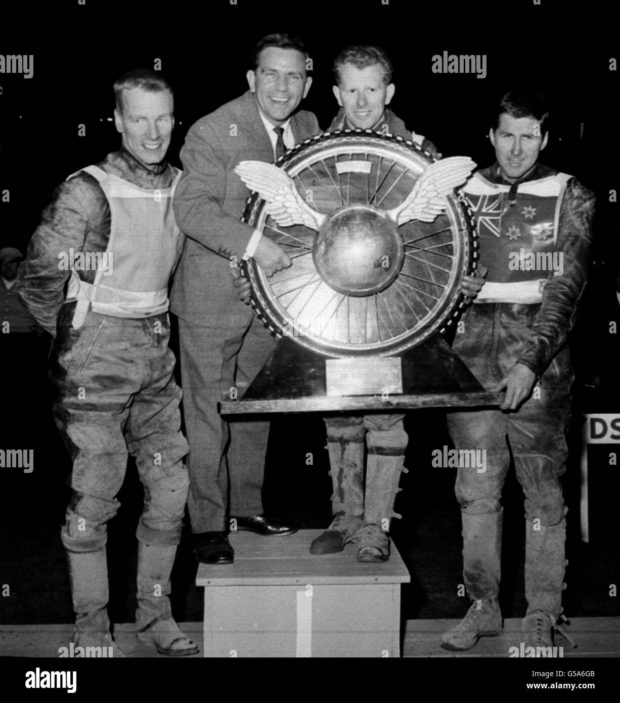 Le comédien Norman Wisdom présente le trophée circuit automobile mondial à Peter Craven au stade Wembbley, à Londres. À droite, Barry Briggs (Nouvelle-Zélande) est arrivé 2e et à gauche est Ove Funclin de Suède qui est arrivé troisième. Banque D'Images