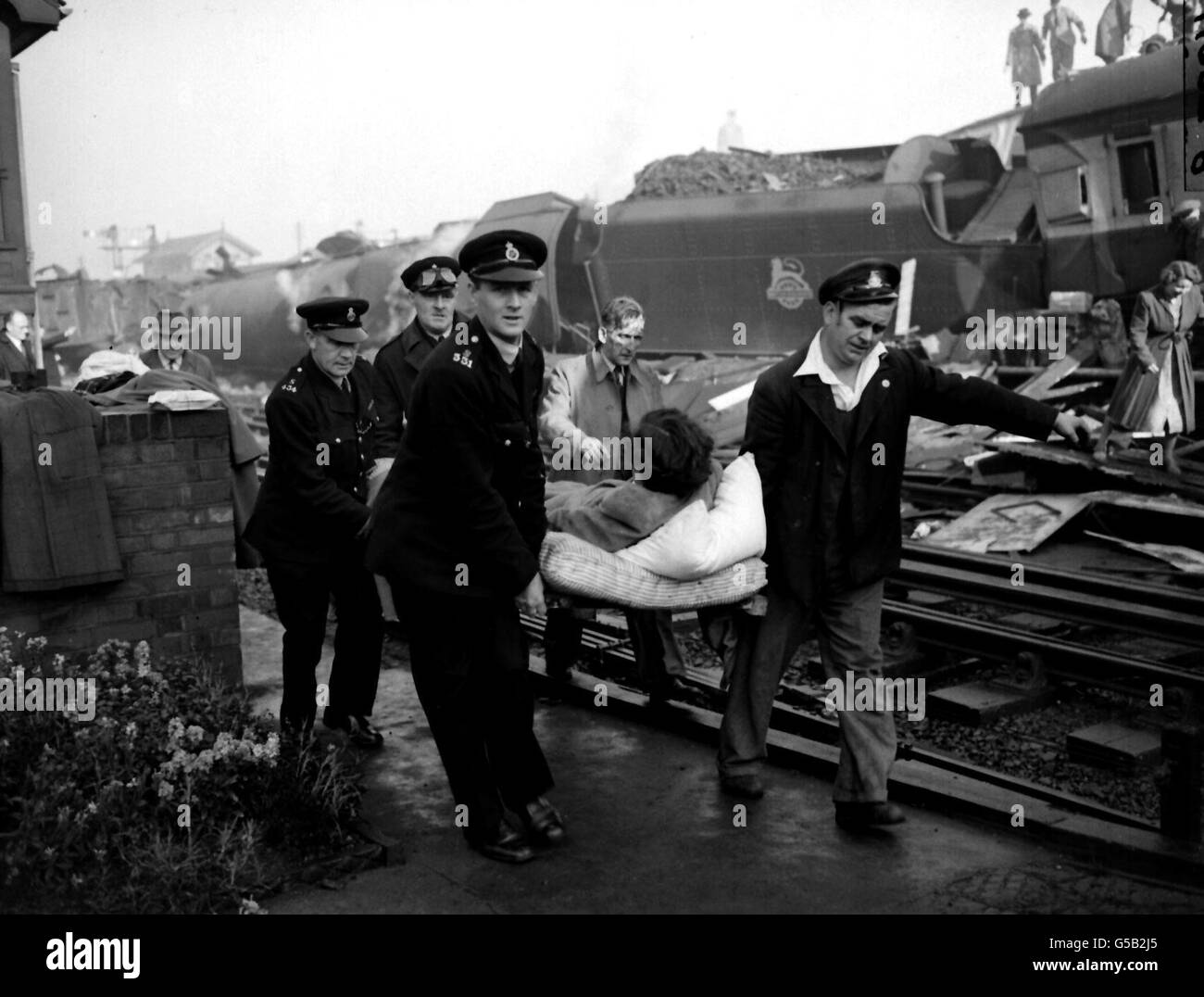 1952: De nombreuses personnes ont été tuées lorsqu'un train express de Perth a heurté un train local à la gare de Harrow et Wealdstone.Un express d'Euston à Liverpool est ensuite entré en collision avec les coachs ayant déraillé, laissant une scène « comme un champ de bataille ».Ici, une femme blessée est transportée de la scène de l'accident.06/10/02 : le 50e anniversaire du pire accident ferroviaire de la Grande-Bretagne en temps de paix a été marqué à un service commémoratif.Les survivants et les proches de ceux qui sont morts ou ont été blessés dans la catastrophe à Harrow et Wealdstone, dans l'ouest de Londres, assistaient au service spécial de Christ Church à Watford, Banque D'Images