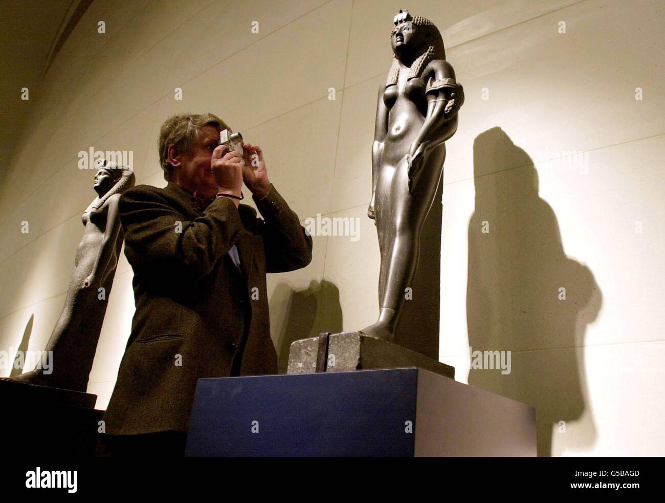 Un photographe prend une photo de la statue de basalte noire de Cléopâtre VII, sculptée entre 51-30 avant J.-C. - l'une des expositions de Cléopâtre d'Égypte : de l'histoire à Myth qui s'ouvre au British Museum. Banque D'Images