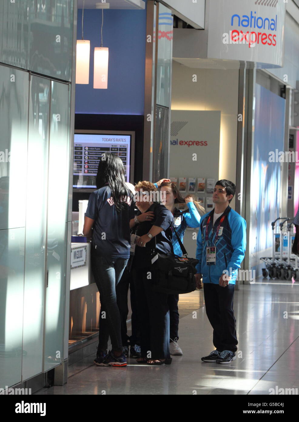 Les membres de l'équipe olympique de la République dominicaine font la queue au Travelex Currency Exchange à l'aéroport de Heathrow, Londres. Banque D'Images