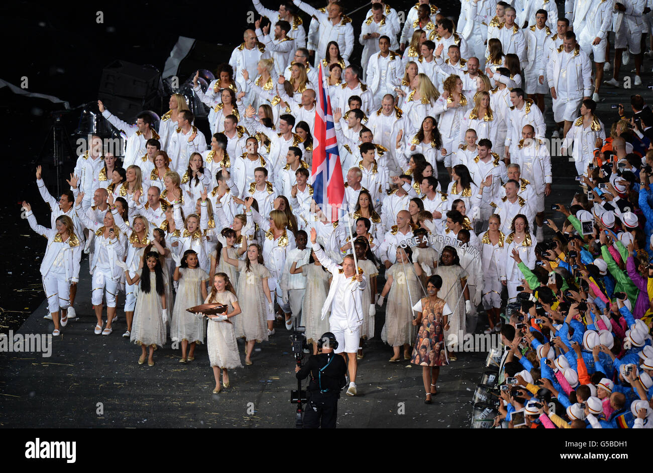 Sir Chris Hoy, de Grande-Bretagne, portant le drapeau britannique, dirige l'équipe lors de la cérémonie d'ouverture des Jeux Olympiques de Londres 2012 au stade olympique de Londres. Banque D'Images