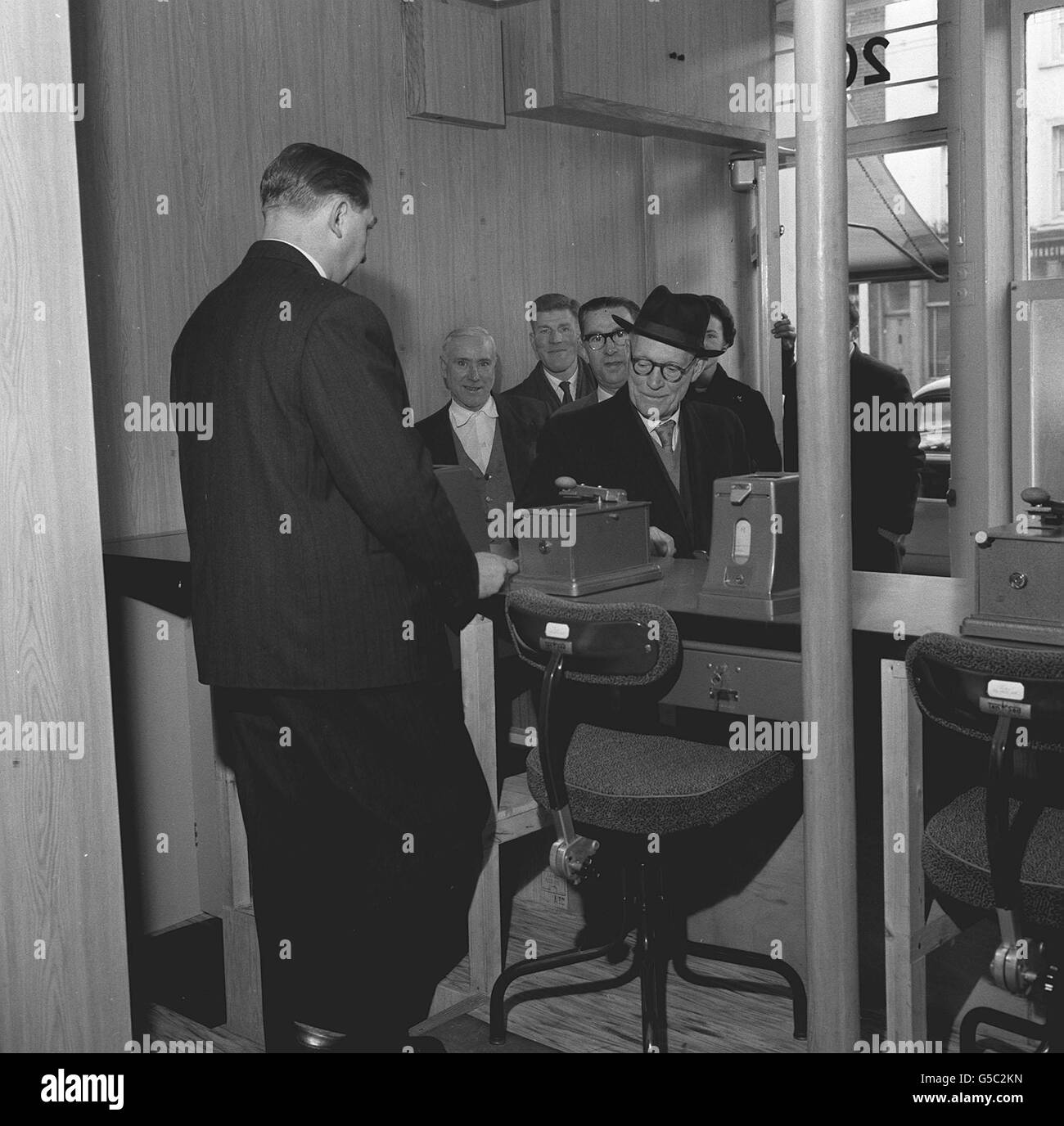 Stanley Morgan, fils du propriétaire Fred Morgan, exploite une machine à reçus pendant que les clients font la queue pour placer leurs Paris dans un bureau de pari autorisé à Kingsland Road, Shoreditch. Banque D'Images