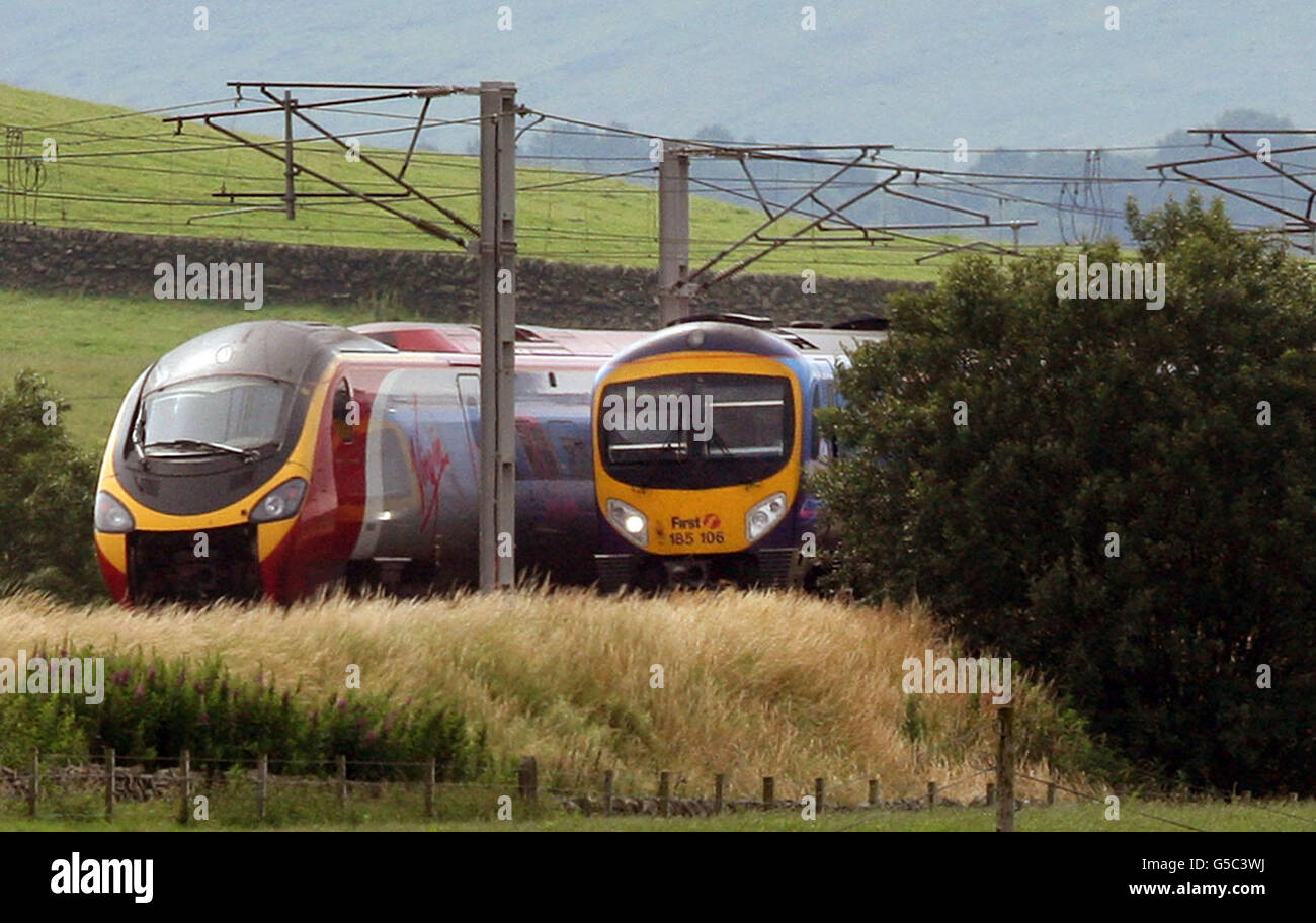 Un train Virgin passe devant un train First Group sur la ligne de la côte ouest près d'Abington, en Écosse, alors que Virgin Rail a perdu sa franchise de ligne principale de la côte ouest, et que la compagnie de transport FirstGroup a pris le relais à partir de décembre, a annoncé aujourd'hui le gouvernement. Banque D'Images