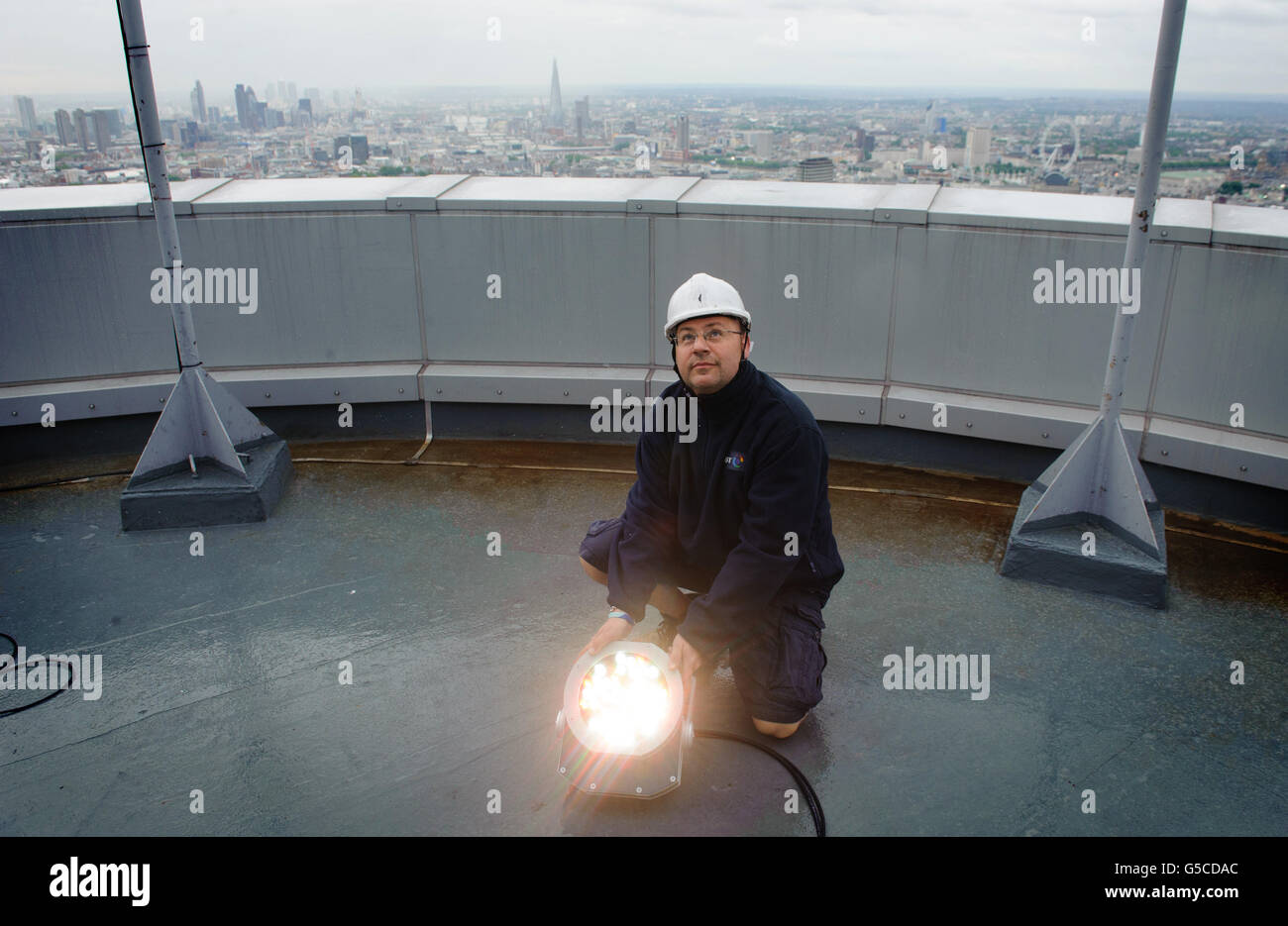 Mark Gravett, le monteur aérien de BT, règle les lumières sur le dessus de la Tour BT, dans le centre de Londres, qui sera illuminée d'or, pour marquer les athlètes de l'équipe GB qui ont remanié le nombre de médailles d'or remportées aux Jeux Olympiques de Beijing en 2008. Banque D'Images