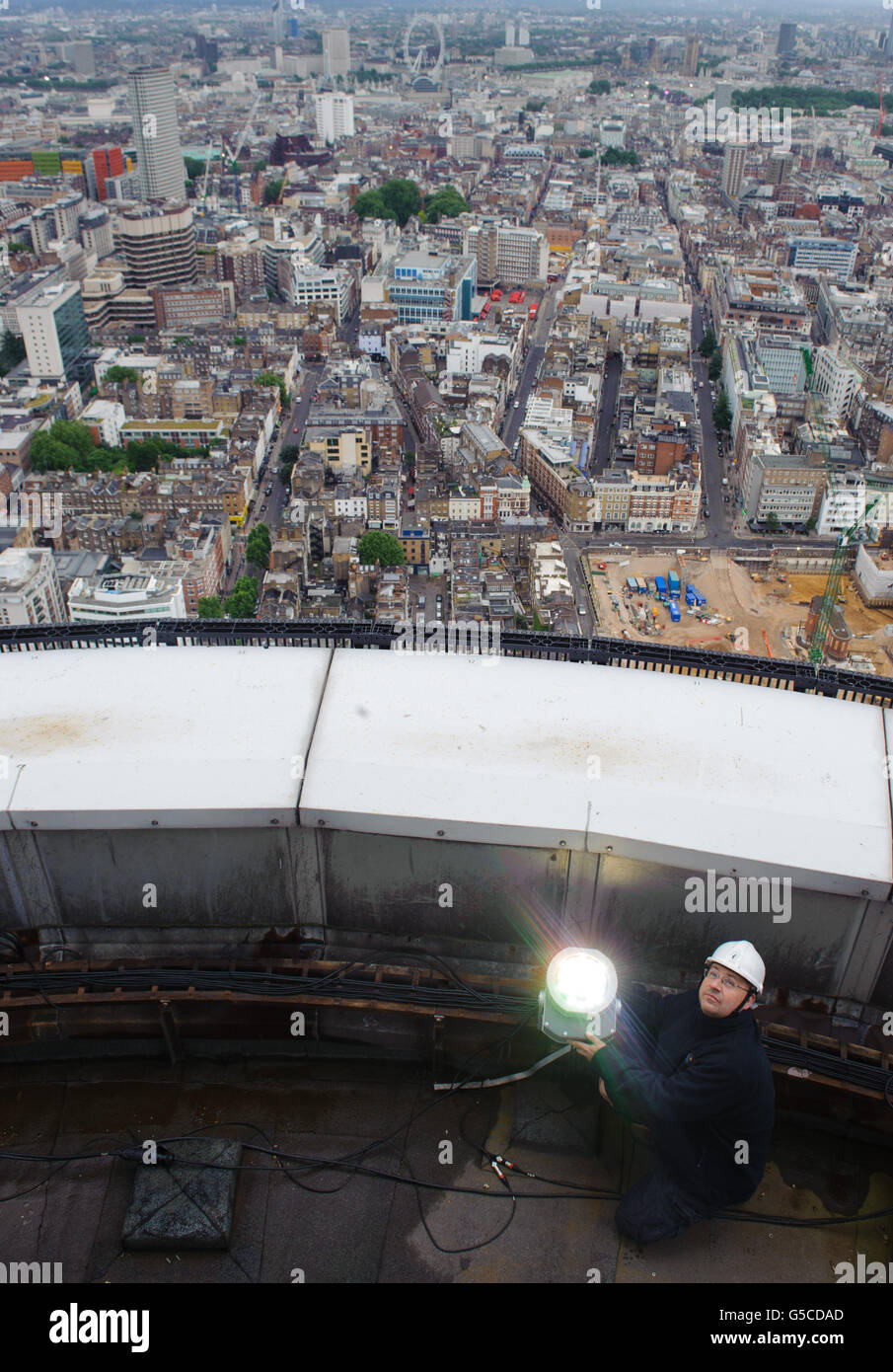 Mark Gravett, le monteur aérien de BT, règle les lumières sur le dessus de la Tour BT, dans le centre de Londres, qui sera illuminée d'or, pour marquer les athlètes de l'équipe GB qui ont remanié le nombre de médailles d'or remportées aux Jeux Olympiques de Beijing en 2008. Banque D'Images