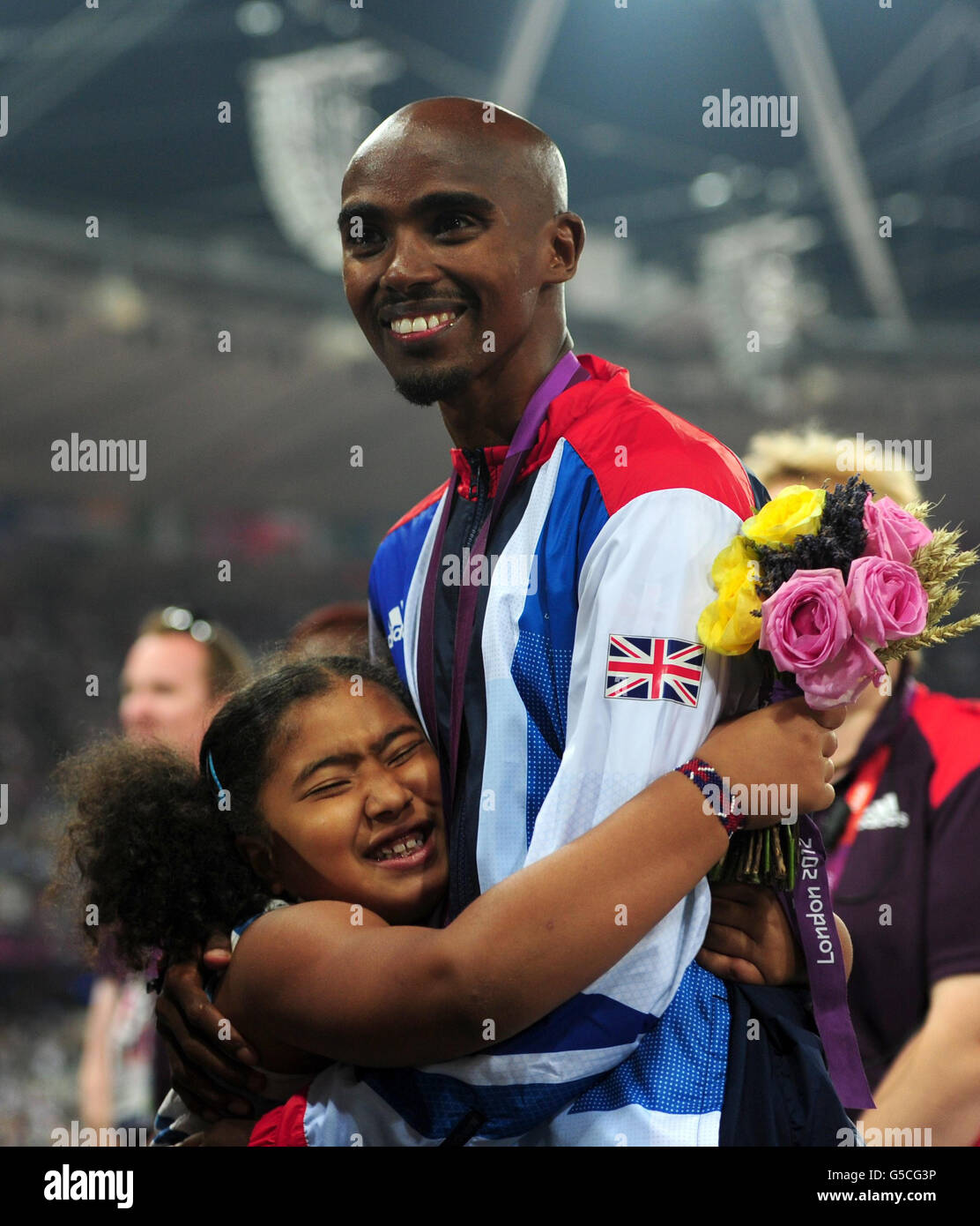 Grande-Bretagne Mo Farah et sa fille Rihanna avec une médaille d'or après la victoire dans la finale masculine de 5000m le quinze jour des Jeux Olympiques de Londres dans le stade olympique, Londres. Banque D'Images