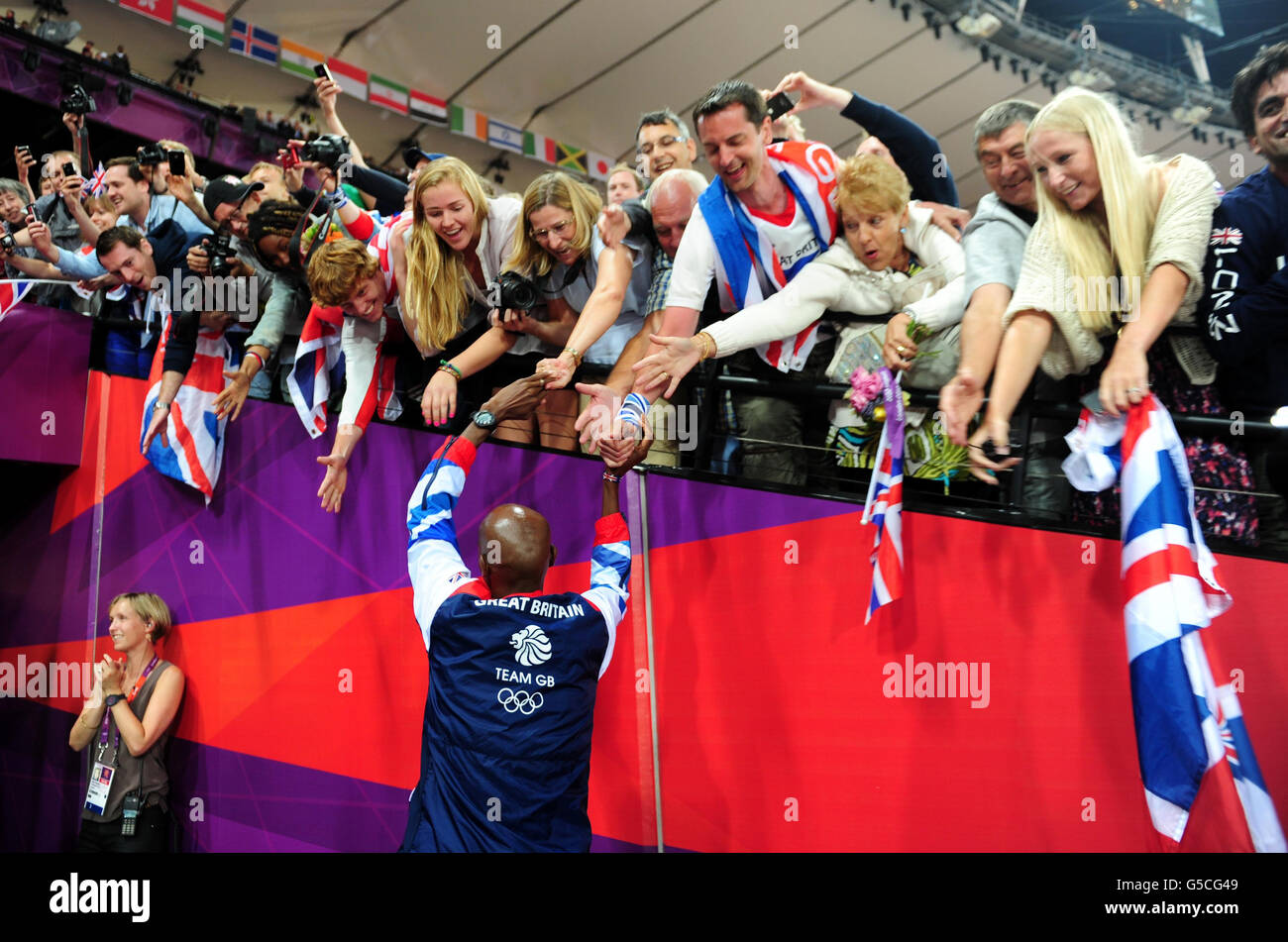 Grande-Bretagne Mo Farah fête avec des fans après la victoire dans la finale masculine de 5000m le quinze jour des Jeux Olympiques de Londres dans le stade olympique, Londres. Banque D'Images