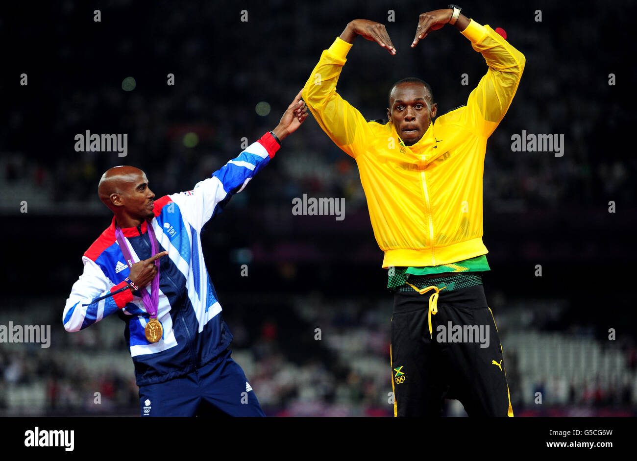 Grande-Bretagne Mo Farah fête avec la victoire d'Usain Bolt lors de la finale masculine de 5000m le quinze jour des Jeux Olympiques de Londres dans le stade olympique de Londres. Banque D'Images