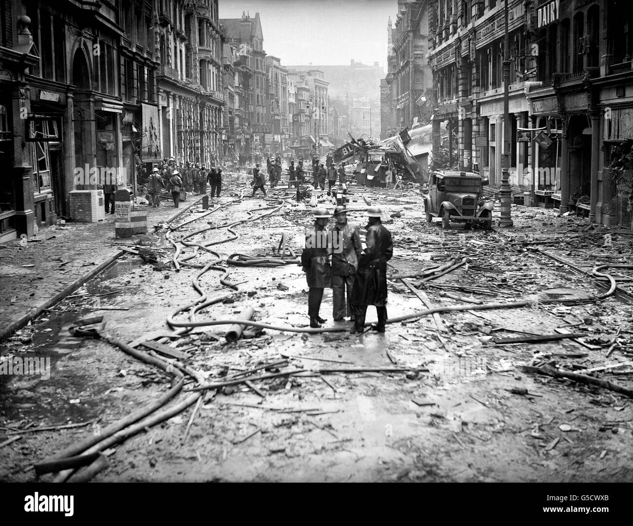 Des pompiers bavardant à High Holborn à la suite d'un raid de la Luftwaffe à Londres. Banque D'Images