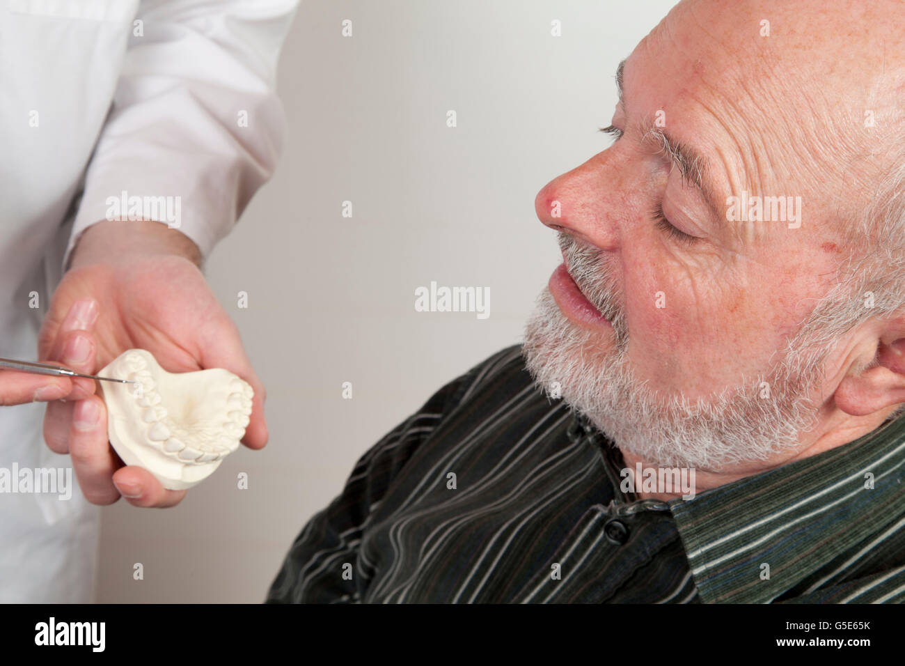 Patient, 59, chez le dentiste, d'être montré un modèle en plâtre Banque D'Images