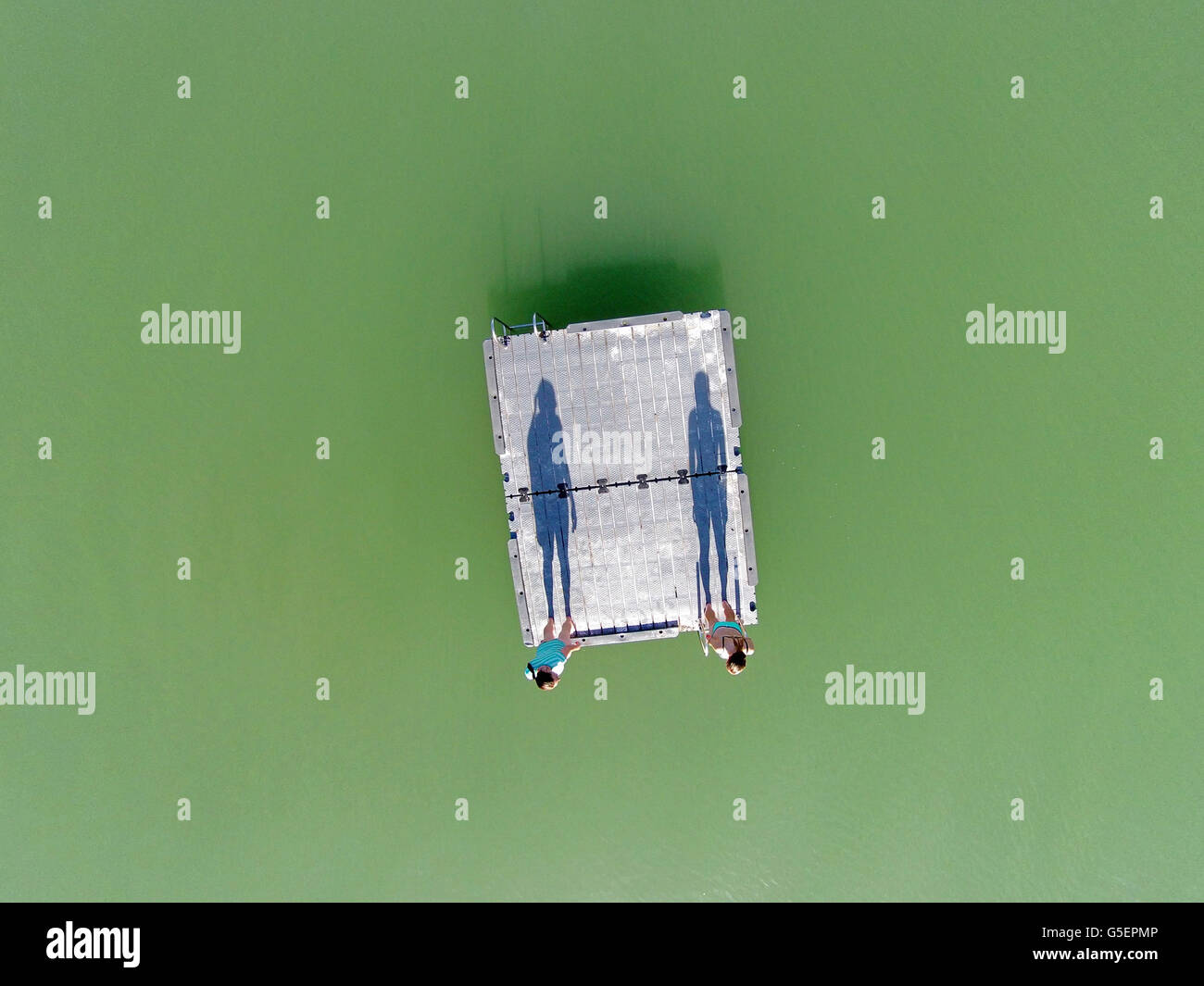 Deux nageurs (et les ombres) debout sur ponton, Bannockburn Inlet, Lake Dunstan, Central Otago, Nouvelle-Zélande - Antenne de drone Banque D'Images