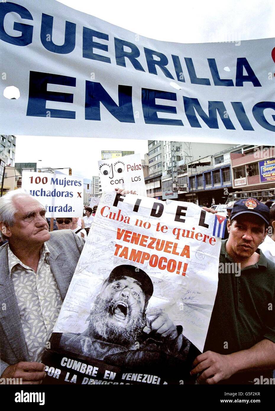 Les protestataires manifester contre le gouvernement vénézuélien en transportant un poster de leader cubain Fidel Castro au cours d'une manifestation à Caracas, 23 juin 2001. Les protestataires manifestaient contre une politique d'échange entre Cuba et le Venezuela. (FILM) AFP PHOTO/Evel GONZALEZ Banque D'Images