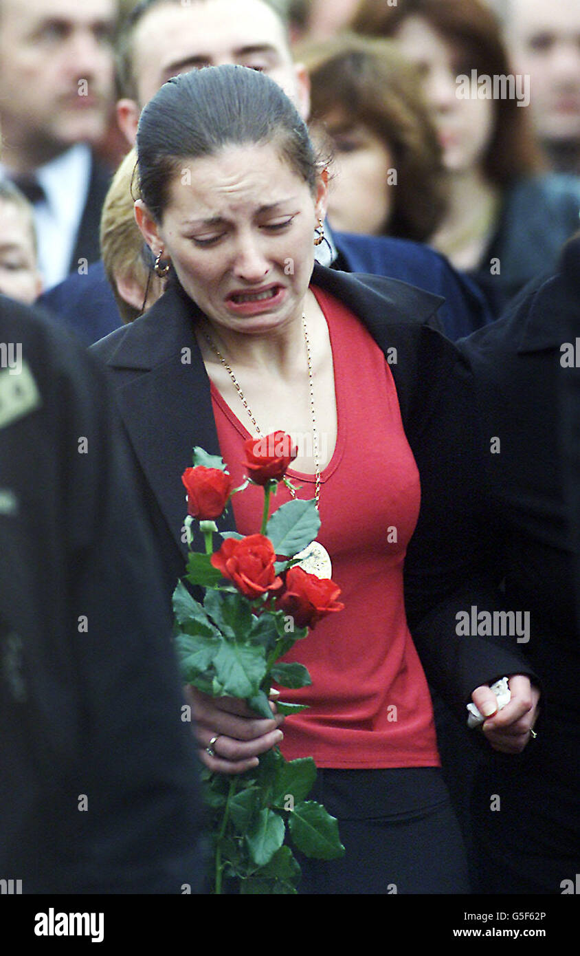 Une Catherine Floyd émotive, fiancée de Ciaran Cummings, porte un bouquet de roses comme elle marche derrière son cercueil.Cummings, qui a été abattu par les Loyalistes, a été enterré dans sa ville natale d'Antrim.L'adolescent a été abattu par un passager.* sur une moto noire comme il a attendu un ascenseur pour travailler tôt mercredi.Le meurtre a été revendiqué par le groupe loyaliste dissident les Red Hand Defenders. Banque D'Images